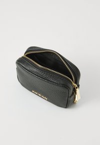Black leather pouch with a textured surface, double gold zipper, and gold hardware accents, featuring an unembellished front panel.