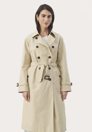 Beige trenchcoat lavet af et glat materiale. Har dobbeltbreasted knapper, en bindebånd i taljen og justerbare manchetremme.