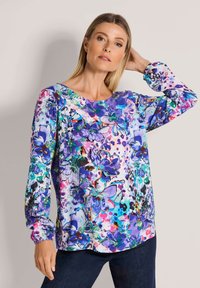 Bunte Bluse mit floralem Muster in Lila-, Blau- und Pinkt�önen, langen Ärmeln mit gerafften Bündchen und rundem Ausschnitt. Glatte Stoffstruktur.