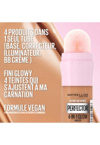 Tube de maquillage Maybelline avec un capuchon rose et un applicateur doux. L'étiquette indique "Perfectors 4-en-1 Glow" et les détails de la formule vegan.