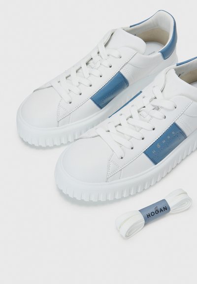 White leather sneakers with blue accents, round toe, textured rubber sole, and flat laces. Includes an extra pair of white laces.