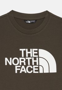 Olivgrön bomullströja med en stor vit logotyp av "The North Face" över bröstet. Klassisk rund halsringning och korta ärmar.