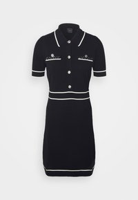 Robe tricotée noire à manches courtes, col blanc et bordure, boutons en argent, tissu texturé et deux poches décoratives avec des sequins.