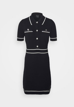 Zwart gebreid jurkje met korte mouwen, witte kraag en bies, zilveren knopen, gestructureerde stof en twee decoratieve zakken met pailletten.