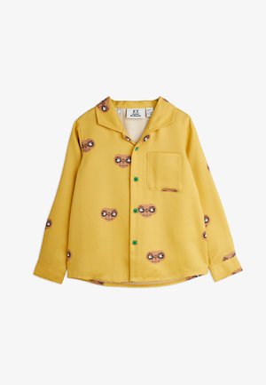 Yellow long-sleeve shirt with an "E.T." character print, featuring a notched collar, green buttons, and single chest pocket. Soft fabric texture.