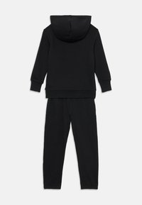 Zwart katoenen trainingspak met een hoodie en bijpassende sweatpants. Beide stukken hebben een strak, minimalistisch design.