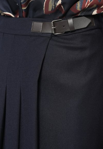 Mörkblå plisserad kjol med en åtsittande midjeband och detaljer i brunt läder med spänne, tillverkad av strukturerad tyg för en skräddarsydd look.
