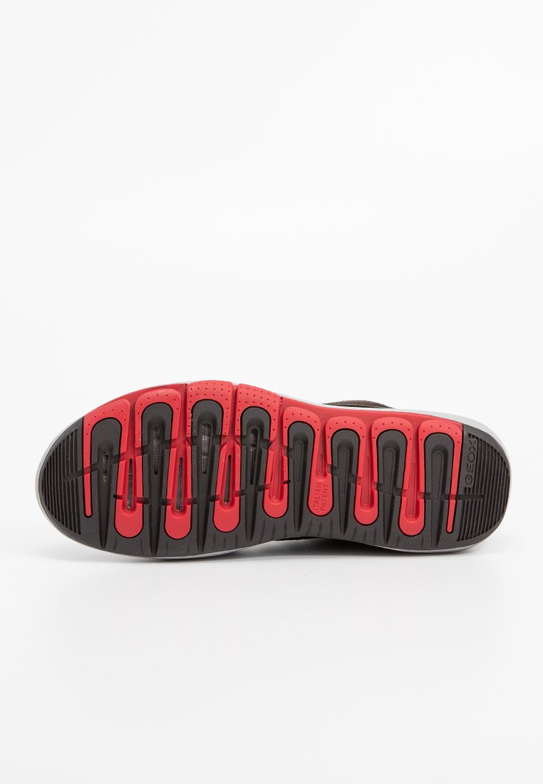 Schuhsohle in Schwarz-Rot; verfügt über Rillen, Abflusslöcher und strukturierte Muster für Grip und Flexibilität.