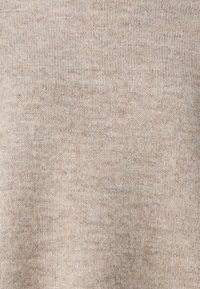 Strickpullover in hellem Beige, mit glatter Textur und feinen Sprenkeln, runder Halsauschnitt und ohne sichtbare Verschlüsse oder Muster.