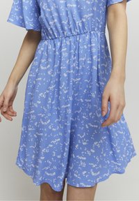 Blue floral dress with short sleeves, elastic waistband, and a soft, lightweight fabric featuring white flower patterns throughout.