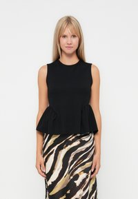 Black sleeveless top with a round neckline and peplum hem, made from a smooth fabric. Paired with a patterned skirt featuring wavy stripes.