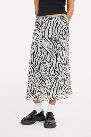 Mid-length skirt in sheer fabric featuring a black and white zebra stripe pattern. The design has a flowing shape with a lightweight texture.