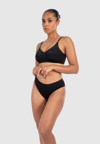 Conjunto de lencería negra que incluye un bralette suave y sin costuras con tirantes ajustables y un bikini de cintura alta con una banda elástica suave.