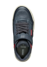 Zapatilla de cuero azul marino con detalles de tela gris, cordones planos y logo rojo. Punta redondeada y suela de goma beige para mayor comodidad.