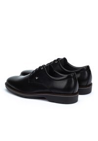 Scarpe da uomo in pelle nera con lacci, punte arrotondate e tacchi bassi, mostrate affiancate su uno sfondo bianco.