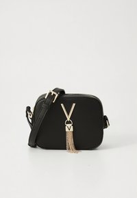 Black rectangular crossbody bag with gold-tone hardware, featuring a V-shaped accent and an attached chain tassel. Adjustable strap included.