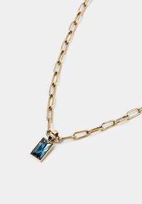Collana in oro con pendente a forma di pietra blu rettangolare ed allungata. La catena è composta da grandi ovali collegati.