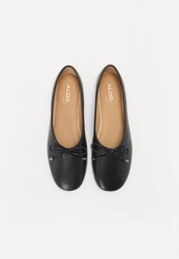 Ballerines noires en cuir lisse avec un bout rond, ornées d'un petit nœud et de détails en métal argenté. Logo ALDO visible.