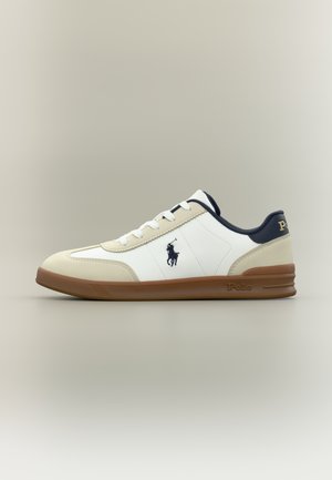 Vita och beige lågskor med brun sula, marinblå detaljer, vita skosnören och mörkblå Polo Ralph Lauren-logotyp på sidan och hälen.