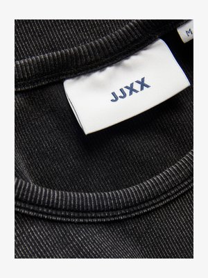 Juodos juostos audinys su apvaliu kaklu ir baltu ženklu, ant kurio parašyta "JJXX" mėlyna spalva, bei papildoma etiketė šalia.