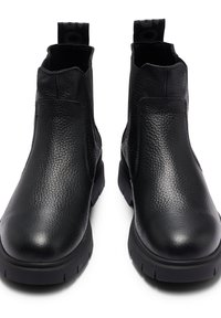 Bottes noires à la cheville en cuir texturé, dotées d'un bout arrondi, de panneaux latéraux élastiques et d'une languette distinctive avec détail du logo.