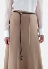 Beige Wolle Rock mit einem flexiblen braunen Kordelzug-Gürtel mit einem goldenen Akzent. Der Stoff hat eine weiche Textur und eine taillierte Passform.