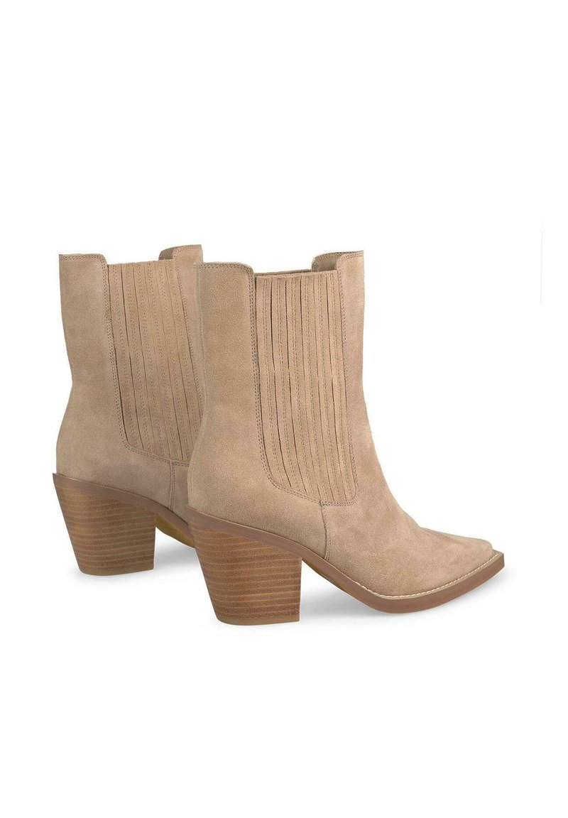Bottes de cowboy en daim beige clair, avec des accents en ribbées verticales, un bout carré et un talon en bois empilé rayé.