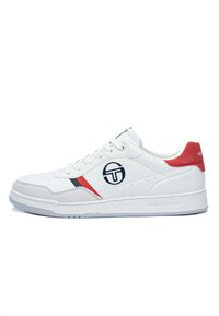 Sneaker bianca con accenti rossi e striscia nera. Presenta una tomaia in pelle liscia, punta arrotondata e logo laterale. Suola piatta bianca.