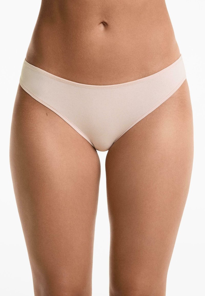 Svetlo béžové bikini spodné prádlo s hladkou, jemnou textúrou, nízkym strihom a minimálnymi švami pre pohodlie a bezšvový vzhľad.