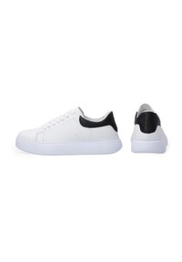 Weiße Leder-Sneaker mit schwarzen Akzenten an der Ferse, runder Zehenpartie, Schnürdesign und einer dicken weißen Gummisohle. Glatte Textur.