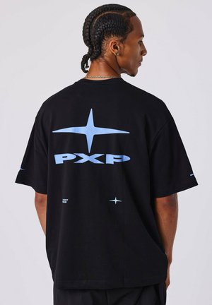 La camiseta de algodón negra presenta un gran logo "PXP" en azul claro y gráficos de estrellas en la parte posterior, con mangas cortas y un ajuste relajado.