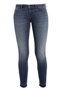 Jeans ajustados de color azul oscuro hechos de denim. Cuentan con una cintura de altura media, bolsillos frontales y un leve desgaste en los muslos. Dobladillo deshilachado en los tobillos.