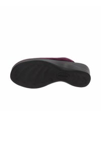 Sole nera in gomma di una scarpa con un motivo testurizzato. Una tomaia viola è visibile sul bordo, che mostra un materiale morbido.