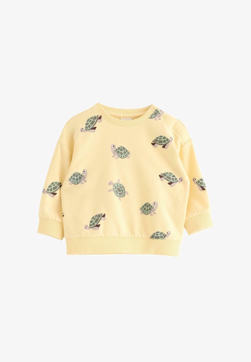 Sweat-shirt jaune à manches longues pour tout-petit avec des imprimés tortues verts et des boutons-pression sur une épaule.