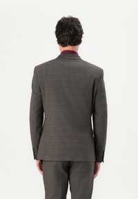 Men’s gray plaid suit with a structured fit. Features a single-breasted jacket, notch lapels, and matching trousers. Fabric has a smooth texture.