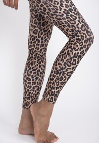 Leggings con stampa leopardata realizzati in tessuto elastico, dotati di un alto punto vita, design aderente e texture morbida.