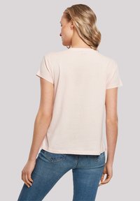 Helles rosa T-Shirt mit kurzen Ärmeln und Rundhalsausschnitt, aus weichem Stoff gefertigt. Die Rückseite hat eine lässige Passform, die leicht über den Hüften endet.