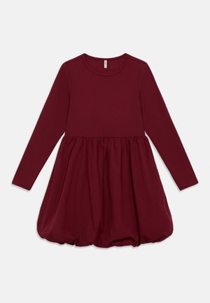 Bordowa sukienka z długim rękawem, dopasowaną górą i rozkloszowanym dołem. Miękki, elastyczny materiał o gładkiej fakturze i zdobionym dołem.