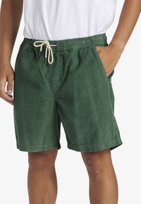 Shorts in corduroy verde con una vita elastica, chiusura con cordoncino, tasche laterali e un fit rilassato.