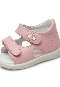 Rosa Leder-Sandale mit zwei Klettverschlüssen, offenen Seiten und einer weißen Innenauskleidung. Weiße Sohle mit runder Form und subtilen Steppdetails.