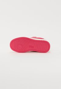 Semelle en caoutchouc rose avec un motif de texture, arborant un logo circulaire et des lignes angulaires pour une adhérence et un soutien supplémentaires.