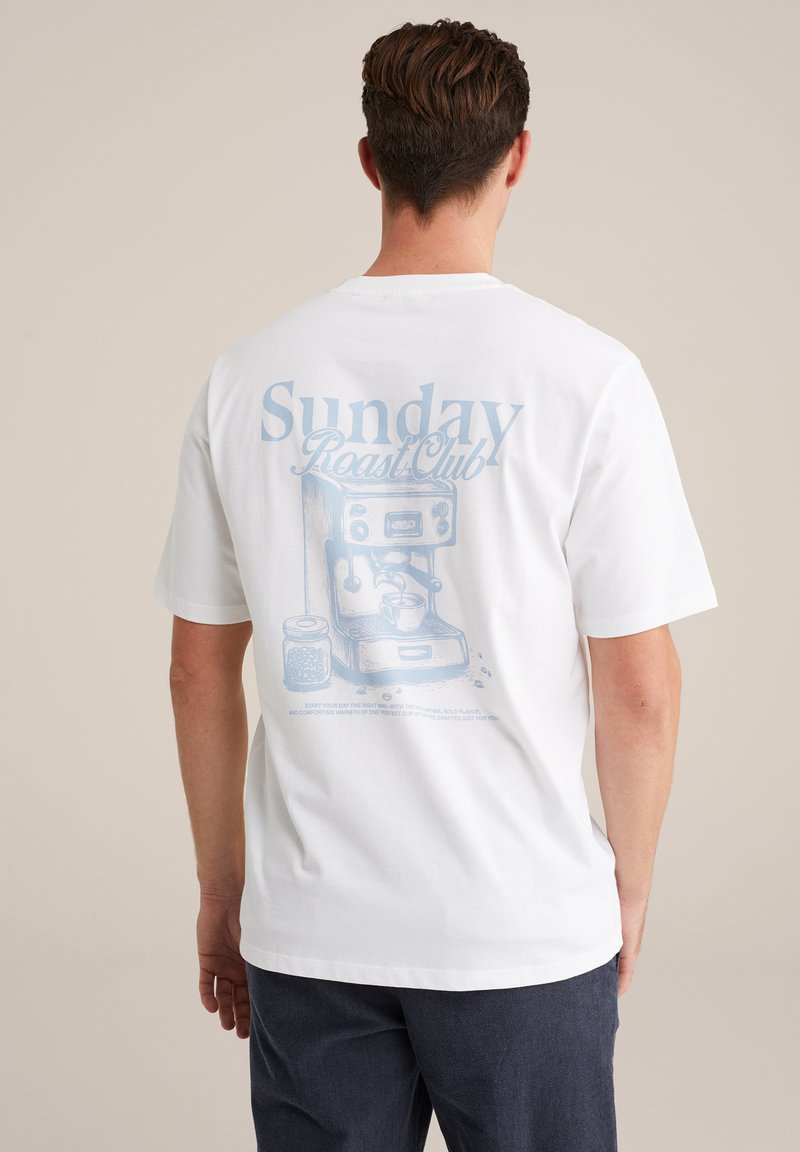 Balta īsām piedurknēm T-kreklu ar zilu grafisko druku, attēlojošu espresso aparātu, un uzrakstu "Sunday Roast Club" aizmugurē.