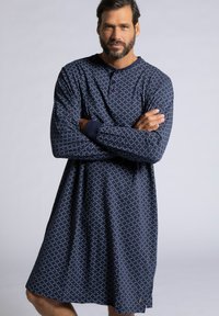 Camicia da notte a fantasia navy con un design geometrico, maniche lunghe, colletto abbottonato e polsini blu in contrasto. Tessuto morbido con una vestibilità comoda.