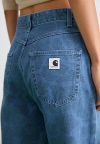Blauwe denim jeans met een subtiel patroon, hoge taille, achterzak met een vierkant stoffen label en gestikte details.