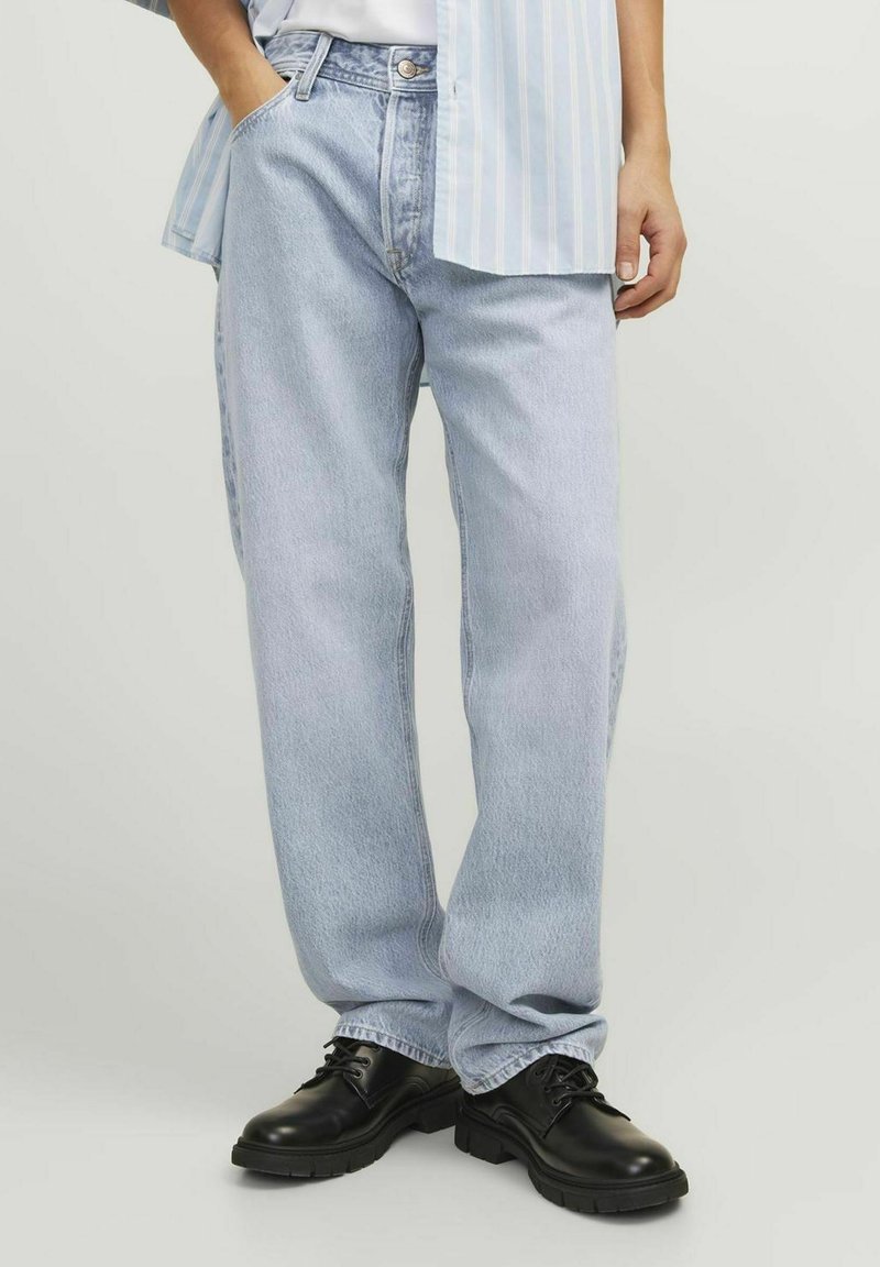 Lichtblauwe denim jeans met een rechte pijp, voorzien van een klassiek vijfzakkenontwerp en subtiele vervaging. Gecombineerd met zwarte veterschoenen.