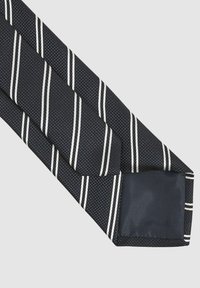 Cravatta blu navy caratterizzata da un tessuto testurizzato con strisce diagonali bianche. La punta è di un blu navy solido con una finitura liscia.