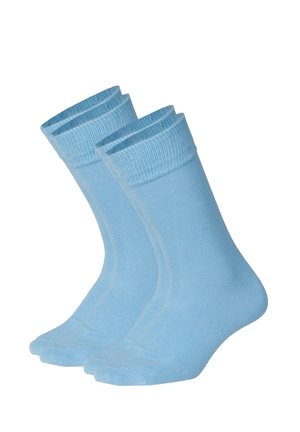 Par ensfarvede lyseblå ankelsokker med ribbede kanter, vist oprejst mod en hvid baggrund.
