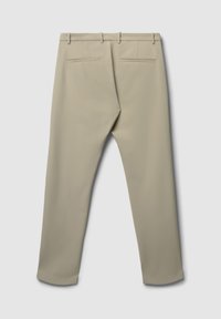 Beige maßgeschneiderte Hosen von hinten gezeigt, mit zwei Paspeltaschen und Gürtelschlaufen auf einem schlichten hellen Hintergrund.