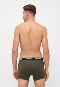 Boxer in verde oliva da uomo con banda nera con logo Levi's, tessuto liscio, forma aderente e senza motivi visibili o dettagli aggiuntivi.