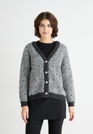Grå og svart mønstrete cardigan med V-hals, fem knapper og ribbede mansjetter og kant. Myk tekstur, lange ermer og løs passform.